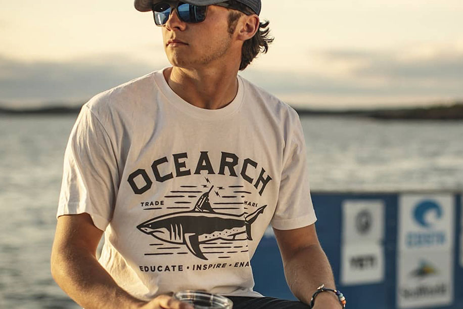 Man in white OCEARCH shirt with shark graphic
