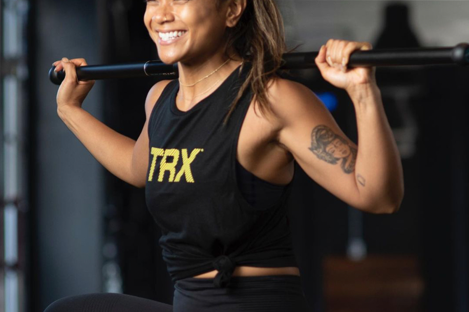 Woman doing squats in black TRX shirt